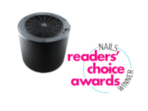 A black, cylindrical air purifier sits beside a colorful logo reading NAILS Readers Choice Awards WINNER in pink and black text, highlighting its IMC Compliance, with curved blue and gray lines encircling the words on a white background. Read more at Aerovex Systems (aerovexsystems.com)