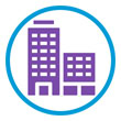 Icon depicting two purple high-rise buildings of varying heights, enclosed in a blue circular border. The taller building on the left features multiple square windows, while the shorter building on the right has fewer windows. This icon is meant to represent the building zone - the 3rd part to the salon 3-zone protection system. Read more at Aerovex Systems (aerovexsystems.com)