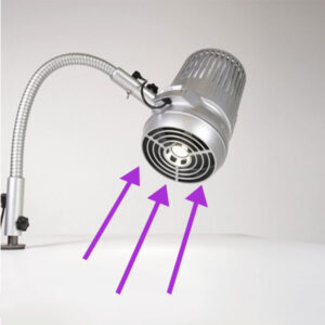 A silver Sunflower II Nail Dust Collector system with a flexible neck is positioned on a surface, angled slightly downward and out. Purple arrows are pointing into the lamp, indicating the flow or direction of the airflow. This is an example of how not to position the Sunflower II. The lamp has a cylindrical design with vent-like openings. Read more at Aerovex Systems (aerovexsystems.com)