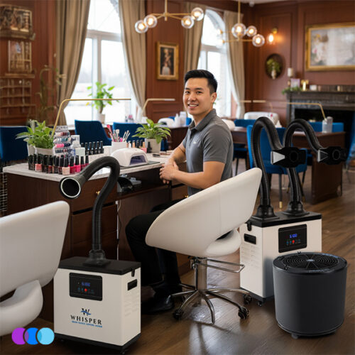 aerovex-whisper-dual-single-white-led-the-one-that-works-totw-salon A man sits smiling at a nail salon workstation, surrounded by two Aerovex Systems Whisper Source Capture Systems, one with a two hose configuration and one with a single hose, LED light configuration. A The One That Works air purifier sits next to him on the floor. The elegant salon features wooden walls, large windows, paintings, and stylish lighting. Nail polish bottles are visible on the desk. Read more at Aerovex Systems (aerovexsystems.com)
