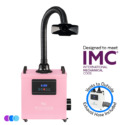 A pink Aerovex Whisper MiniVent­™ Source Capture System air purifier with a flexible black exhaust hose attached. The front panel displays controls and a digital screen. Text reads "Designed to meet IMC" and "Vents to Outside, Exhaust Hose Included" with a small inset image of the hose. Read more at Aerovex Systems (aerovexsystems.com)